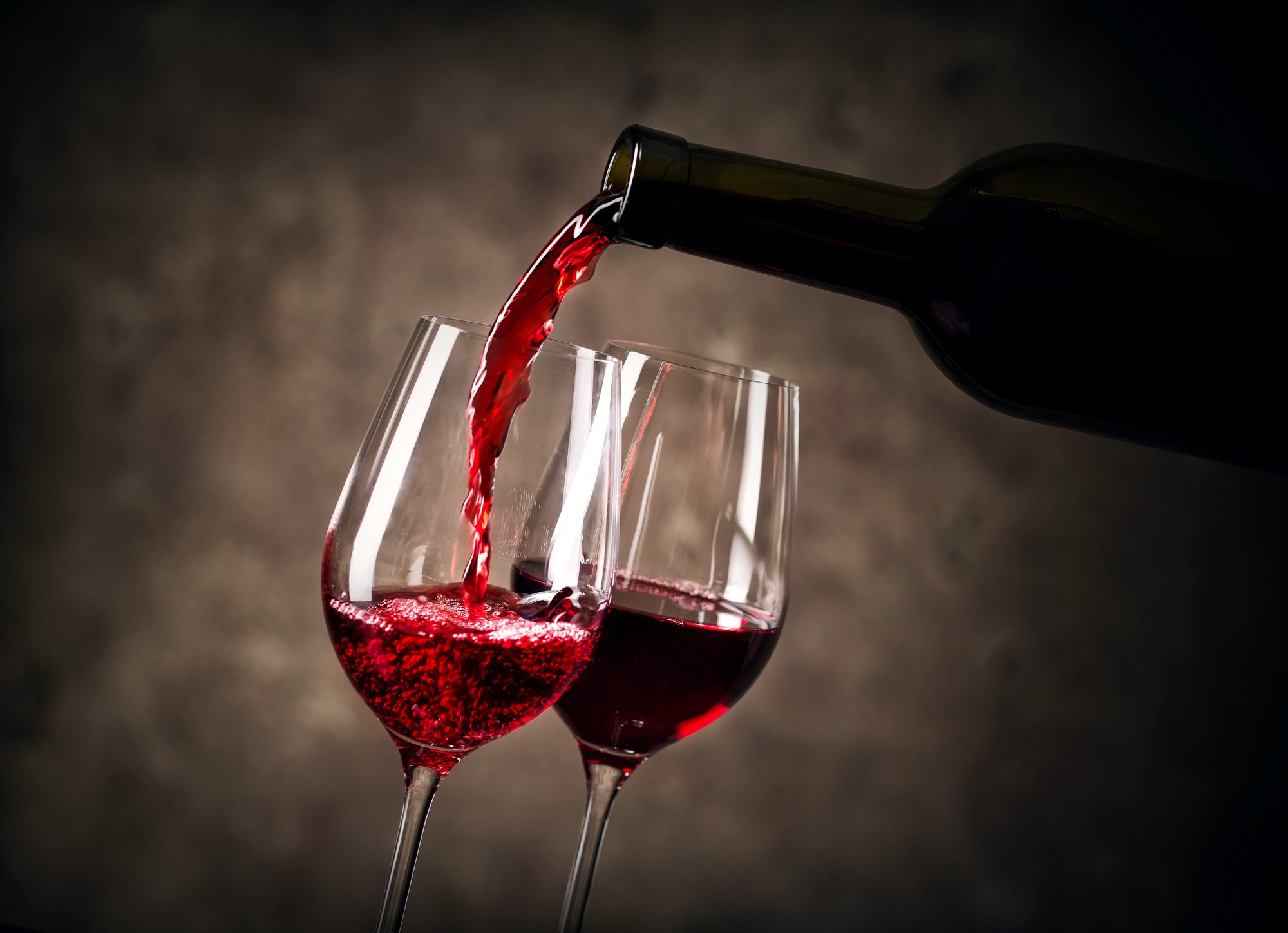 Red wine pouring into glass from bottle